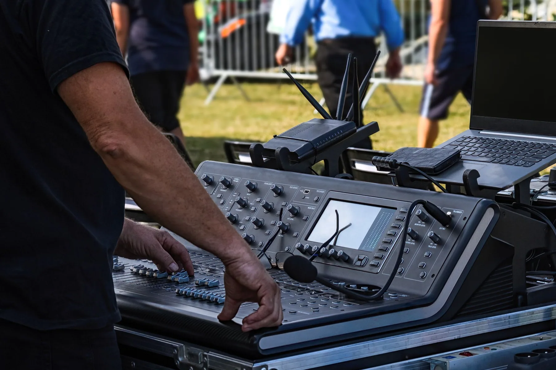 Técnico operando una consola digital de audio durante un evento